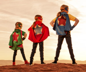 Three girls dressed at superheroes